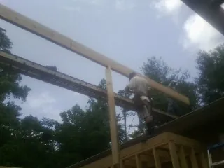 Carpenter setting a ridge beam over a new addition frame — Ice Dam Removal by Roofing Brothers in Sheldon